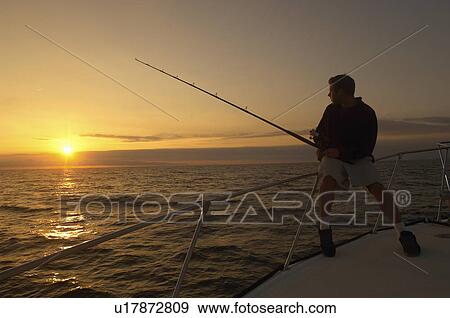 Fisherman on boat at sunset View Large Photo Image Stock Photo - Fisherman on boat at sunset. Fotosearch