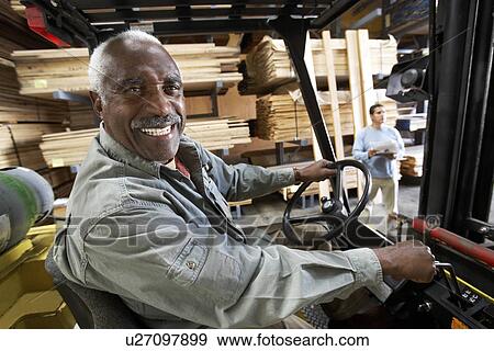 Forklift Driver on forklift in Lumber Warehouse View Large Photo Image Stock Photo - Forklift Driver on forklift in Lumber Warehouse. Fotosearch
