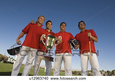 Stock Image - Four polo players with trophy. Fotosearch