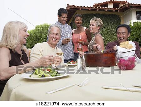 Friends eating and drinking in garden View Large Photo Image Picture - Friends eating and drinking in garden. Fotosearch