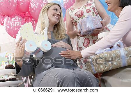 Friends giving gifts to woman at baby shower View Large Photo Image Stock Image - Friends giving gifts to woman at baby shower. Fotosearch