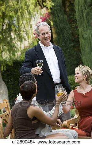 Picture - Friends toasting outdoors. Fotosearch
