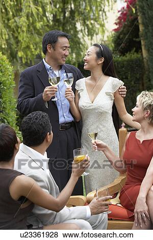 Friends toasting with drinks in garden View Large Photo Image Stock Photo - Friends toasting with drinks in garden. Fotosearch