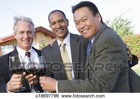 Stock Photograph - Friends toasting with wine in garden. Fotosearch