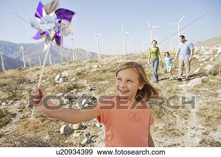 Girl (7-9) with pinwheel standing on wind farm, portrait View Large Photo Image Stock Photo - Girl (7-9) with pinwheel standing on wind farm, portrait. Fotosearch