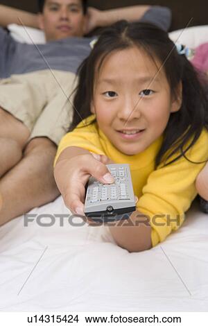 Picture - Girl holding remote control. Fotosearch