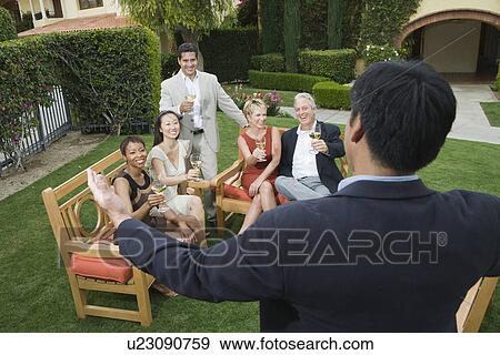 Stock Photo - Group of friends relaxing outdoors. Fotosearch