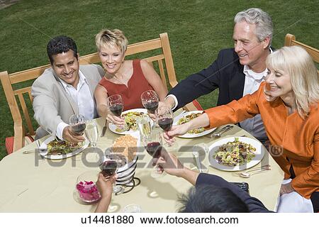 Stock Image - Group of friends toasting outdoors. Fotosearch