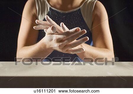 Gymnast (13-15) rubbing chalk into hands, mid section View Large Photo Image Stock Image - Gymnast (13-15) rubbing chalk into hands, mid section. Fotosearch