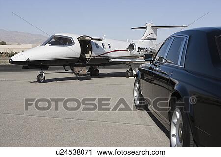 Stock Image - Limousine and private jet on landing strip.. Fotosearch