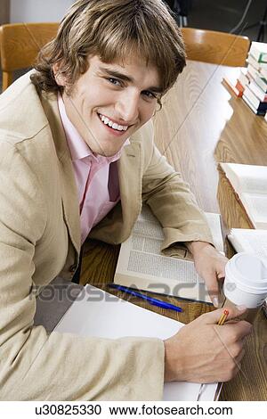 Male college student studying at library desk View Large Photo Image Stock Image - Male college student studying at library desk. Fotosearch