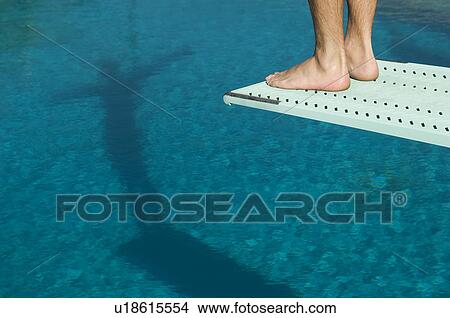 Picture - Male swimmer standing on diving board. Fotosearch