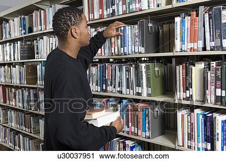 Male University student in library View Large Photo Image Stock Image - Male University student in library. Fotosearch