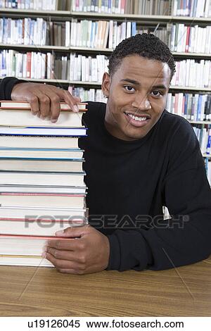 Stock Photography - Male University student in library, portrait. Fotosearch