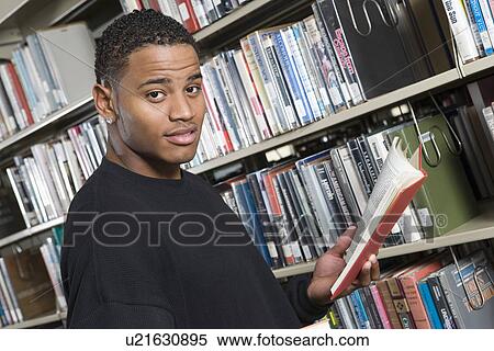 Stock Photography - Male University student in library, portrait. Fotosearch