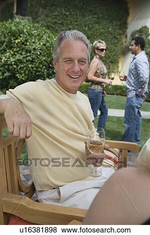 Stock Photo - Man drinking wine in garden. Fotosearch