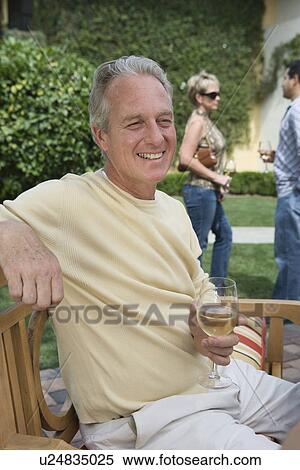Stock Photography - Man drinking wine in garden. Fotosearch