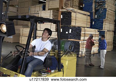 Man driving forklift in warehouse of wood View Large Photo Image Stock Photo - Man driving forklift in warehouse of wood. Fotosearch
