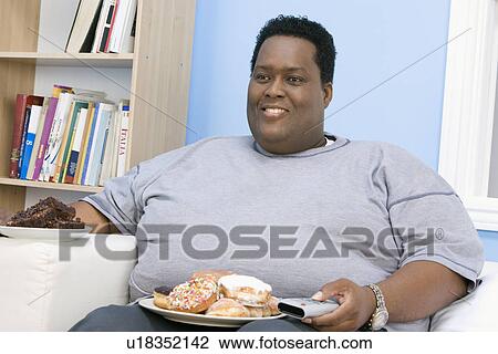 Stock Image - Man Eating Junk Food. Fotosearch