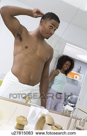 Stock Image - Man Looking in Bathroom Mirror. Fotosearch