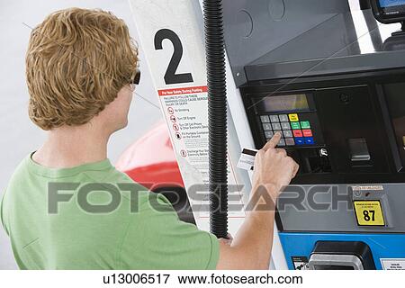 Man operating fuel pump payment kiosk View Large Photo Image Stock Photo - Man operating fuel pump payment kiosk. Fotosearch