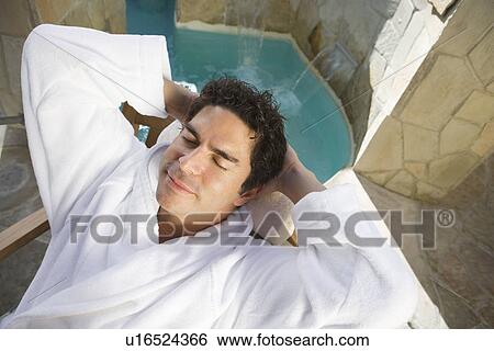 Man relaxing by swimming pool View Large Photo Image Stock Photograph - Man relaxing by swimming pool. Fotosearch