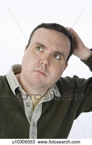 Stock Image - Man scratching head, looking up. Fotosearch