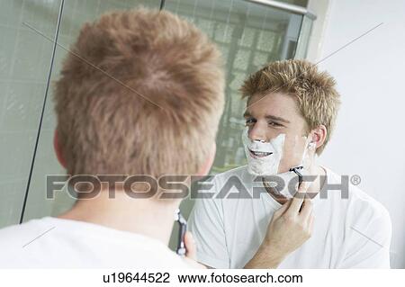 Man shaving in front of bathroom mirror View Large Photo Image Stock Image - Man shaving in front of bathroom mirror. Fotosearch