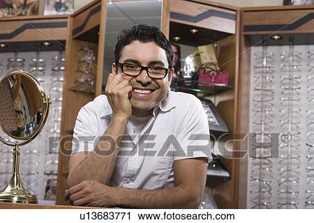 Man trying on eyeglasses in store View Large Photo Image Stock Image - Man trying on eyeglasses in store. Fotosearch