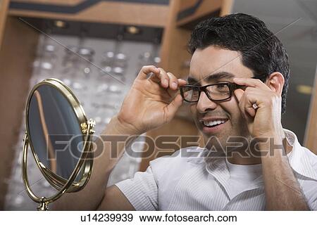 Man trying on eyeglasses in store View Large Photo Image Stock Photo - Man trying on eyeglasses in store. Fotosearch