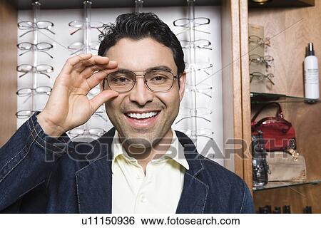 Man trying on eyeglasses in store View Large Photo Image Stock Photograph - Man trying on eyeglasses in store. Fotosearch