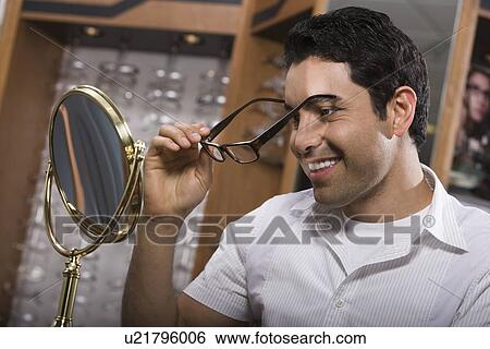 Man trying on eyeglasses in store View Large Photo Image Stock Photograph - Man trying on eyeglasses in store. Fotosearch
