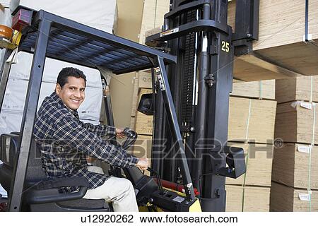 Man using forklift to lift stack of wood View Large Photo Image Stock Image - Man using forklift to lift stack of wood. Fotosearch