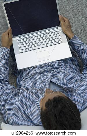 Stock Photograph - Man using laptop in hammock. Fotosearch