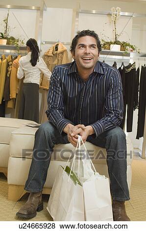 Stock Photo - Man waiting in boutique, portrait. Fotosearch