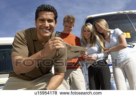 Stock Photo - Man with keys to RV, customers in background, portrait. Fotosearch