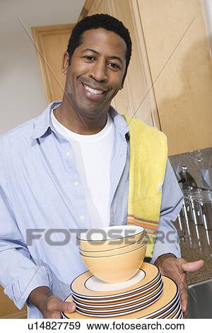 Man with stack of dishes View Large Photo Image Stock Photo - Man with stack of dishes. Fotosearch