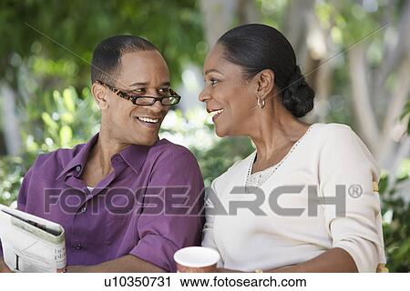 Mature couple sitting together, outdoors View Large Photo Image Stock Image - Mature couple sitting together, outdoors. Fotosearch