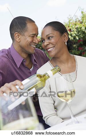 Mature man pouring wine for his elegant wife View Large Photo Image Stock Photo - Mature man pouring wine for his elegant wife. Fotosearch