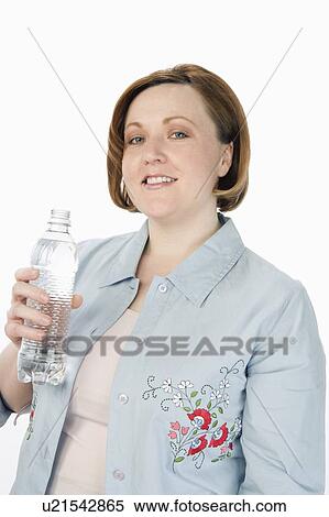 Stock Photography - Mature woman holding bottle of water, half-length portrait. Fotosearch
