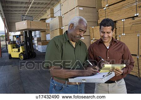 Men stock-taking in warehouse View Large Photo Image Stock Image - Men stock-taking in warehouse. Fotosearch