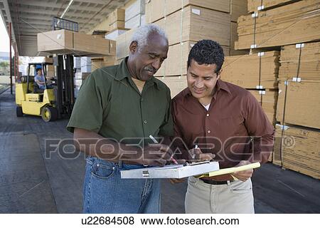 Stock Photo - Men stock-taking in warehouse. Fotosearch