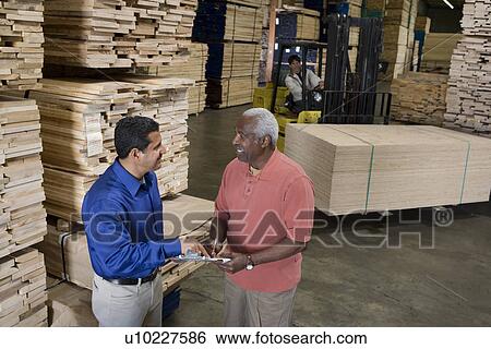 Stock Photograph - Men stock-taking in warehouse. Fotosearch