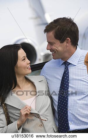 Stock Photograph - Mid-adult business couple smiling.. Fotosearch
