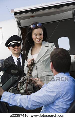 Mid-adult businesswoman getting out of airplane, two men assisting. View Large Photo Image Stock Photograph - Mid-adult businesswoman getting out of airplane, two men assisting.. Fotosearch