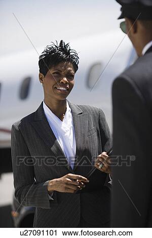 Mid-adult businesswoman talking to chauffeur in front of airplane. View Large Photo Image Stock Image - Mid-adult businesswoman talking to chauffeur in front of airplane.. Fotosearch