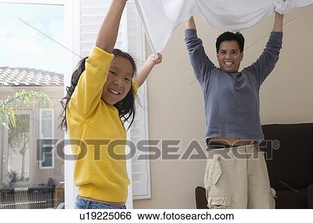 Mid-adult man and his daughter making a bed View Large Photo Image Stock Photograph - Mid-adult man and his daughter making a bed. Fotosearch