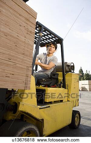 Mid-adult man driving forklift View Large Photo Image Stock Photo - Mid-adult man driving forklift. Fotosearch