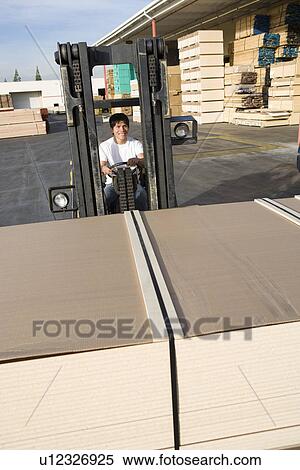 Mid-adult man driving forklift View Large Photo Image Stock Photography - Mid-adult man driving forklift. Fotosearch