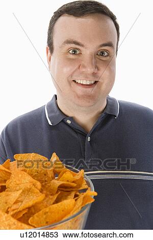Mid-adult man holding glass bowl of potato chips View Large Photo Image Stock Image - Mid-adult man holding glass bowl of potato chips. Fotosearch